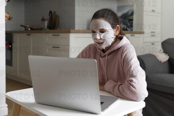 Young woman with beauty mask at home. Snackable wellness concept. Self care for home office . Quick face mask for home spa.