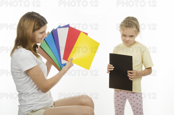Girl shows girl pictures with flowers, and the girl said what color the pictures