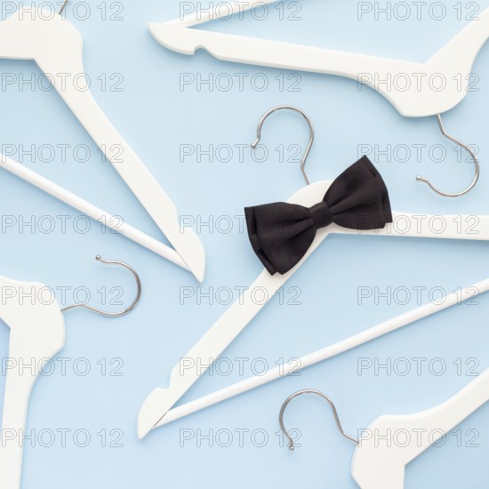 Creative top view flat lay white wooden hangers isolated pastel blue background with copy space minimalism style. Template fashion feminine blog social media sale store promo design shopping concept