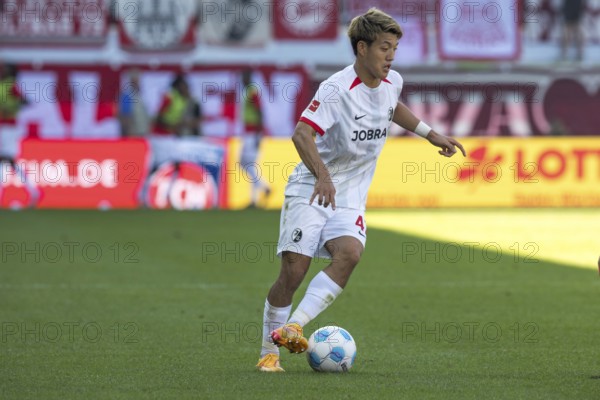Football match, Ritsu DOAN SC Freiburg with left leg and outside tear on the ball, Voith-Arena football stadium, Heidenheim