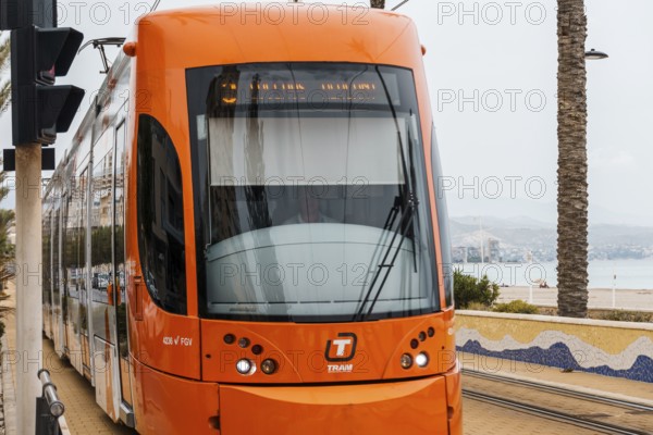 Alicante, Spain, October 14, 2023: Orange streetcar running along the promenade between Alicante and San Juan, Europe