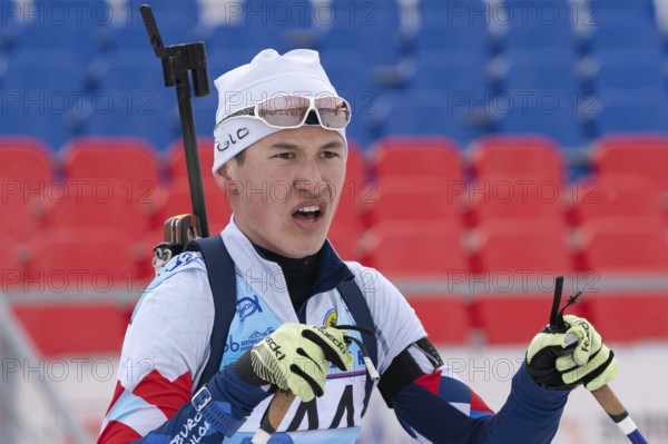 Portrait of Russian sportsman biathlete Ilmir Akhtyamov Saint Petersburg at finish after rifle shooting and skiing. Open regional youth biathlon competitions East Cup. Kamchatka, Russia, Apr 12, 2019, Europe