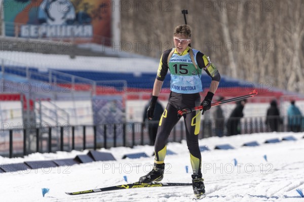 Sportsman biathlete Khanzutin Artem skiing on ski track distance biathlon stadium during Junior biathlon competitions East Cup. Petropavlovsk City, Kamchatka Peninsula, Russian Far East, Apr 14, 2019