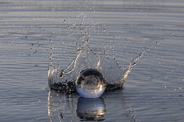 A glass sphere creates water droplets with a dynamic water crown, Mindelheim, Allgäu, Bavaria, Germany, Europe