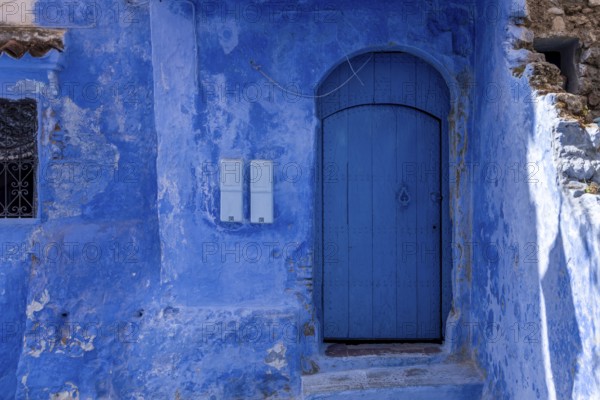 Vibrant blue colored wooden door in downtown Chefchaouen, Morocco, Africa