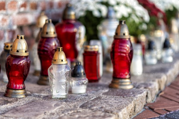 Cemetery with flowers and grave candles on a memorial day