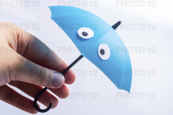Hand with small tiny umbrella in hand