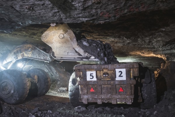 The loader pours copper ore on a truck in the mine