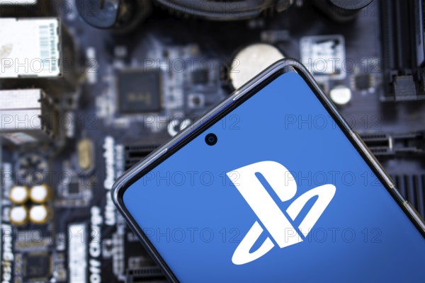 Person holding cellphone with logo of video gaming platform PlayStation Network (PSN) in front of cihp