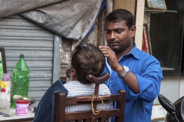 Barber shaving man, chor bazaar, Mumbai, Maharashtra, India, Asia