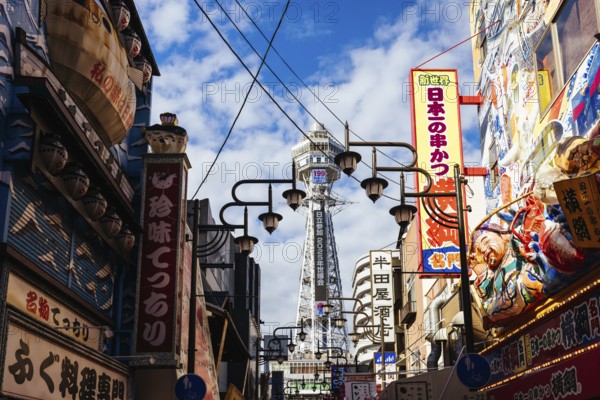 OSAKA, JAPAN - SEPTEMBER 26 2024: The famous Shinsekai area with Tsutenkaku Tower on a clear autumn day in Osaka, Japan, Asia