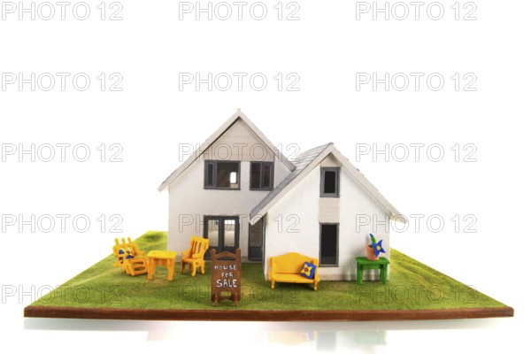 Miniature house for sale isolated over white background