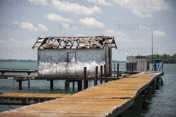 A weathered dock and shed sit along on the Detroit River along the shoreline of Southwestern Ontario, Canada, North America