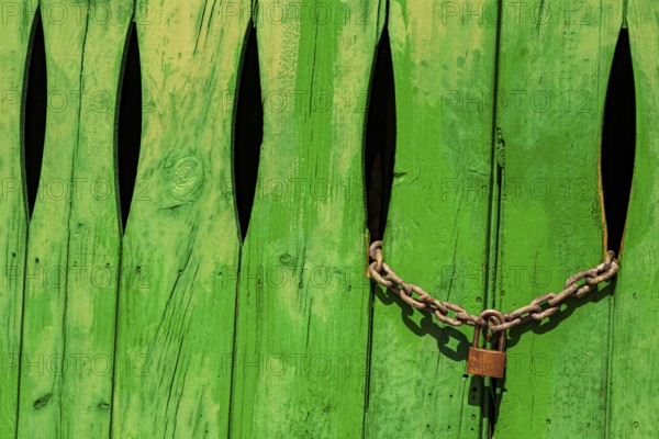 Green door in the stone wall with lock locked in Cala Figuera Mallorca Spain
