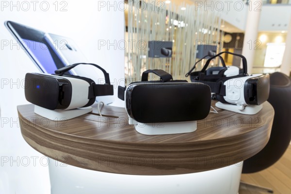 Virtual reality (VR) headsets (glasses) on a table. VR is immersive multimedia or computer-simulated reality - a computer technology that replicates an environment and simulates a user's physical presence and environment to allow for user interaction