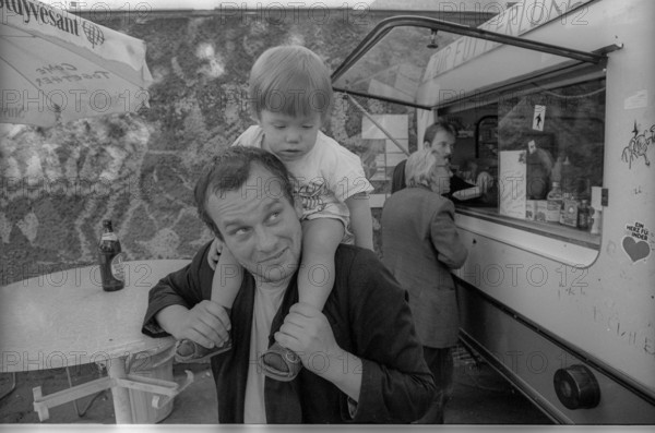 Germany, Berlin, 21 July 1991, poet Peter Wawerzinek (Schappy) with his daughter, (to the feeding hatch), Europe