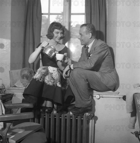 In the 1950s. Actors Maj-Britt Nilsson and Hasse Ekman enjoys a coffee cup during a break when filming a movie. She pours him the coffee from an aluminium coffee pot. Sweden 1953 Kristoffersson Ref BL42-7