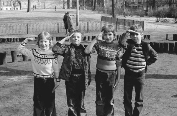 09/09/1978 GDR East Berlin district of Prenzlauer Berg. Three boys and a girl on a playground at Letteplatz with military salute. Berlin