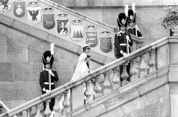 Wedding of Carl XVI Gustaf and Silvia Sommerlath. Carl XVI Gustaf, King of Sweden. Born 30 april 1946. The wedding 19 june 1976 in Stockholm. Queen Silvia in her wedding dress with king Carl XVI Gustaf on the stairway to the royal castle in Stockholm with crowds of people in the background cheering