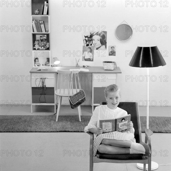 In the 1960s. A teenage girl in her typical 1960s room, a desk and her things with pictures of her idols of the wall Audrey Hepburn and Elvis Presley. Sweden 1960