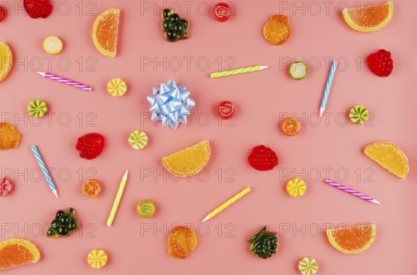 Flat lay view at sweet background of different type candies on pink