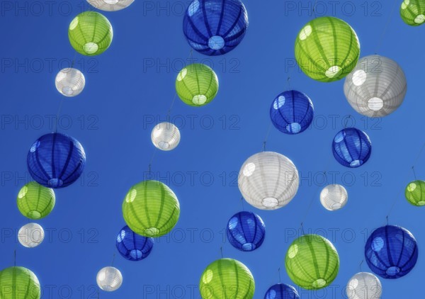 Party with colourful lampions hanging under a blue sky
