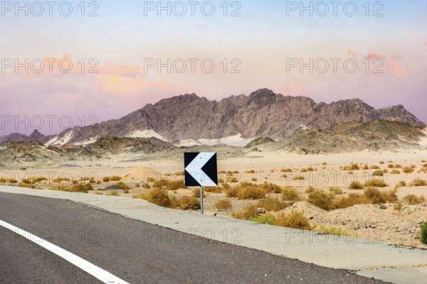 Sign on road in the desert of Egypt at sunset