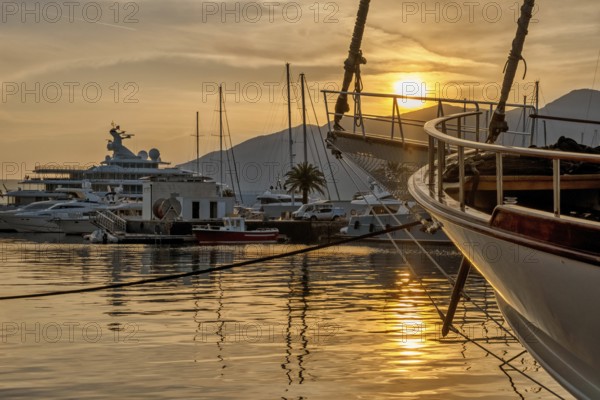 View of Harbor and marina with moored yachts and motorboats at sunset