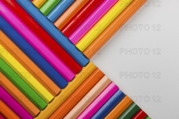 Abstract composition of a set wooden colour pencils against a white background