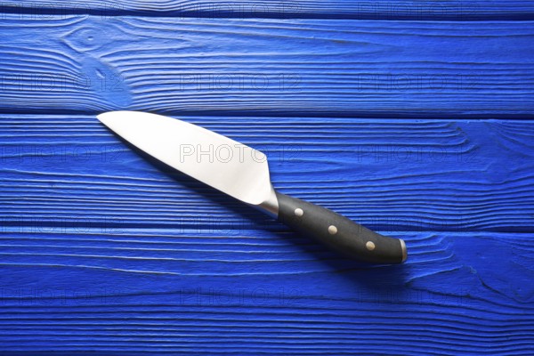 Chef tools black knife on a blue wooden background