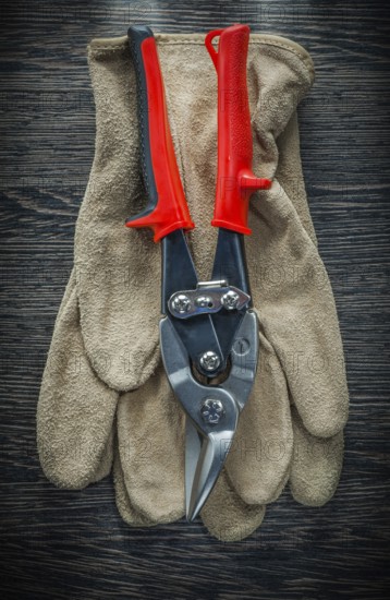 Protective gloves steel cutter on wooden board