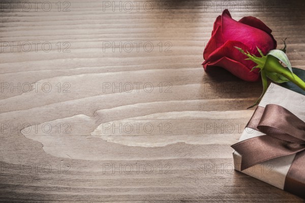 Packed present with brown ribbon red rose holiday concept