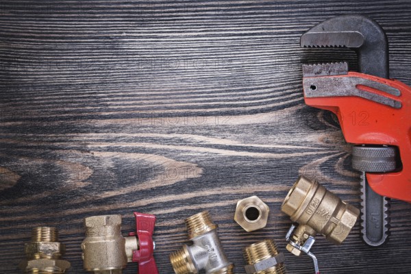 Composition of plumbers equipment on wooden board plumbing concept