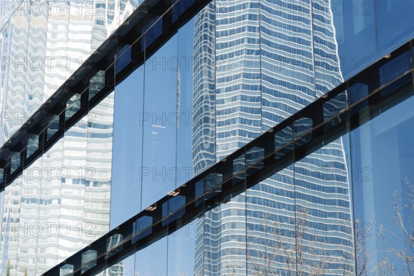 Modern office building exterior and reflections on glass. Low angle view
