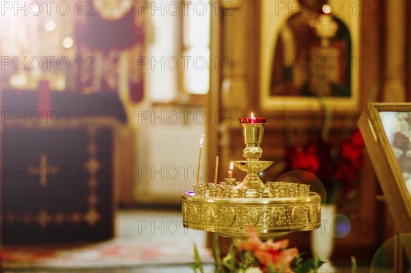 A church interior with a brass candle holder featuring lit candles
