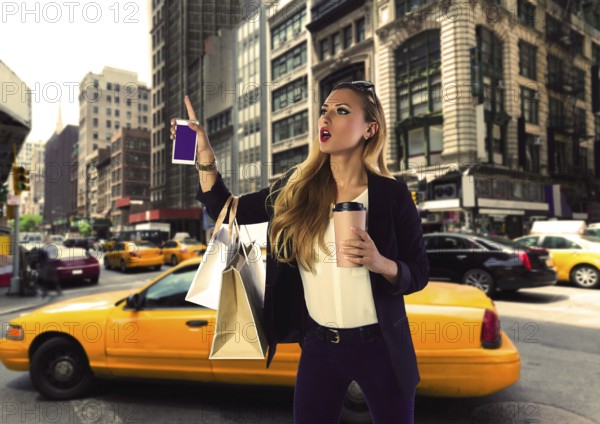 Blond shopping tourist girl calling a yellow Taxi in New York fifth avenue Photomount