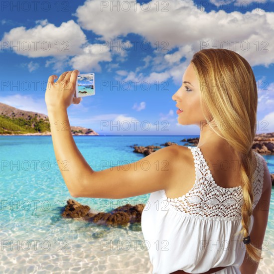 Blond tourist in Mallorca taking photos of Cala Agulla photomount