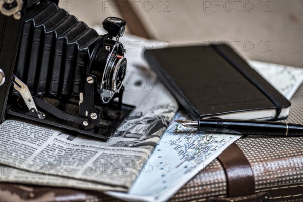 Still life with an old camera, pen, glasses and a road map in vintage style. Memories from travelling with an old camera, pen, glasses and a road map