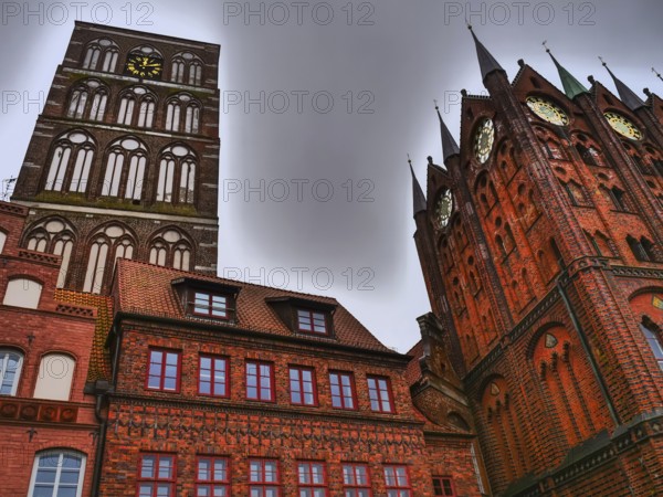 High gothic church towers and brick clock tower, surrounded by historic buildings under a gloomy sky, stralsund, mecklenburg, germany