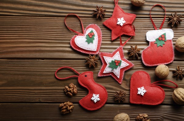 Handmade rustic Christmas tree decorations with walnuts and cones on wooden table