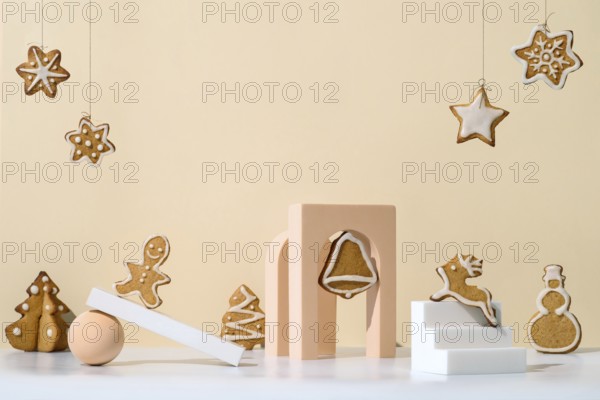 Christmas composition with gingerbread cookies in trendy minimalistic style. Different geometrical shapes, podiums and christmas cookies on neutral cream background. Copy space