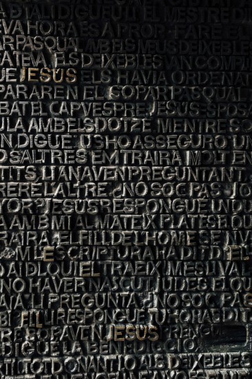 Detail with word Jesus on the bronze door of Passion facade of Sagrada Familia in Barcelona. The gospel doors contain text from the New Testament depicting the Passion of Christ.