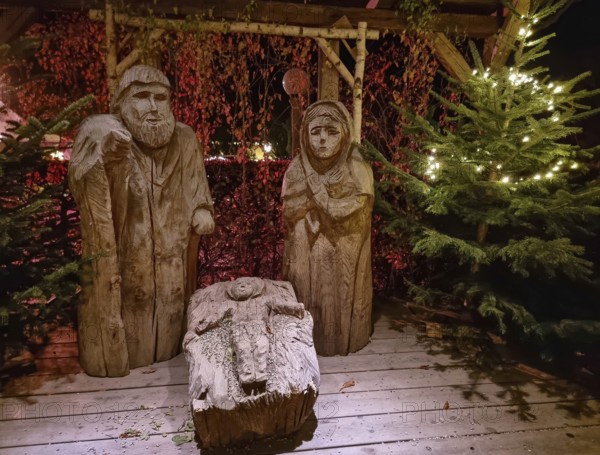 Traditional Christmas nativity scene with figures made out of wood, the birth of Jesus Christ in the manger surrounded by Joseph and Mary.