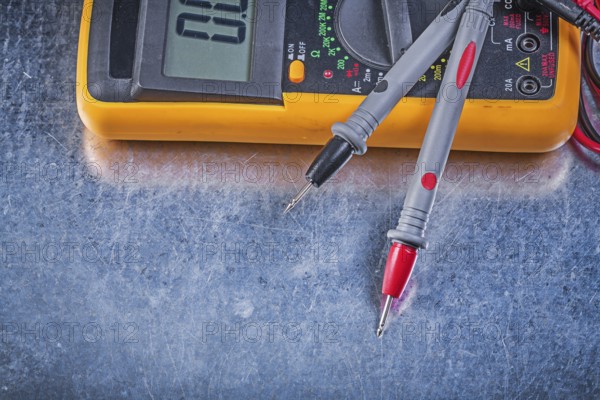 Digital electric tester test leads on metallic background