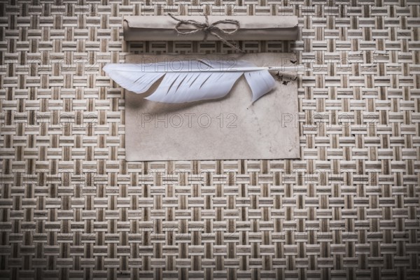 Vintage clean sheet paper roll plume on woven wooden matting