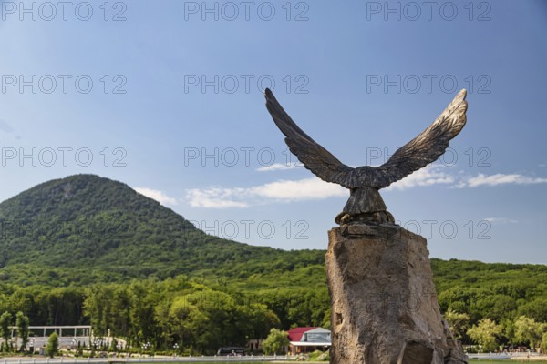 Bronze statue of the eagle-the symbol of the Caucasus on the background of mountains