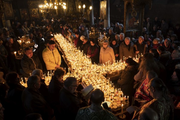 Blagoevgrad, Bulgaria - February 10, 2019: Worshippers light candles on jars with honey during a religious ritual marking the day of Saint Haralampi - the Orthodox patron saint of beekeepers - in the church of the Presentation of the Blessed Virgin
