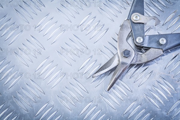 Flat nose pliers on corrugated metal background construction concept