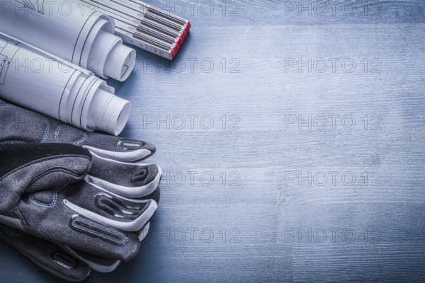 Copyspace image working gloves rolled blueprints and wood meter