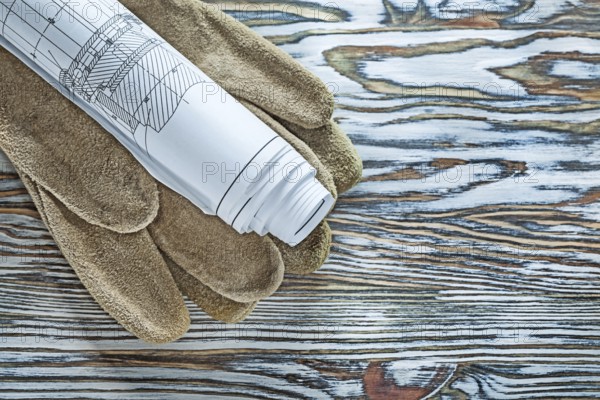 Leather safety gloves construction plans on vintage wooden board